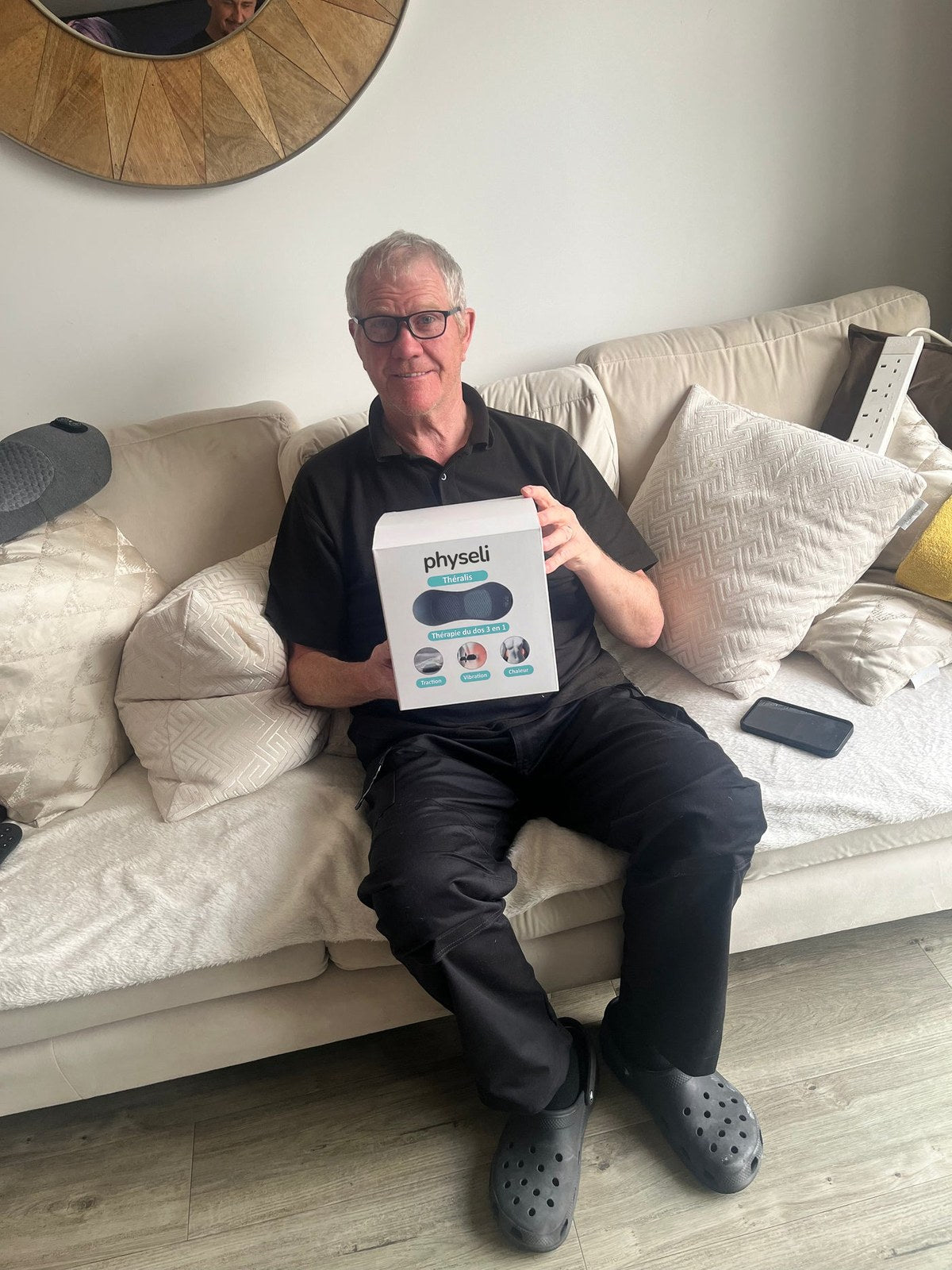 Client assis sur son canapé avec la boîte Théralis